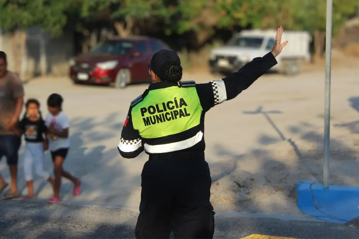 Agente de tránsito apoyando el cruce de estudiantes frente a una escuela en La Paz